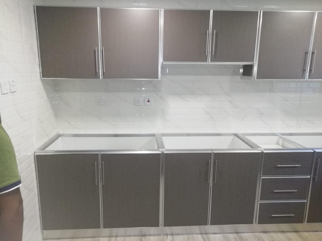 Kitchen cabinets made with aluminium channel border and marble top 