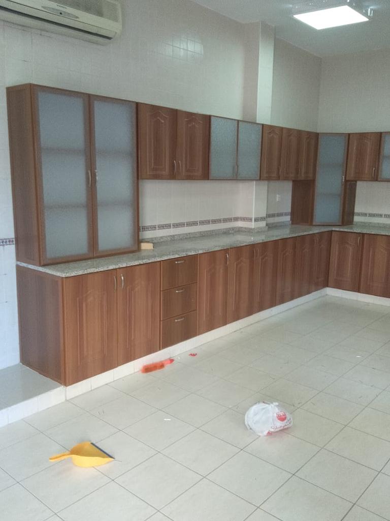 Kitchen cabinets made with wood using marble top slabs and glass portion 